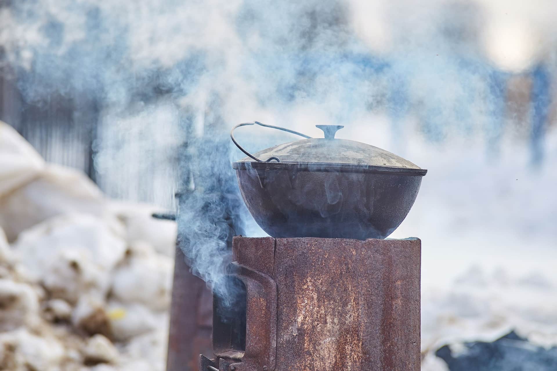 A cold cast-iron Dutch oven with its lid ajar on a dark work surface